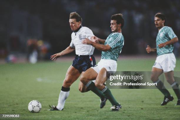 English footballer Stuart Pearce is tackled by West Germany player Thomas Berthold during the semi final match between West Germany and England in...