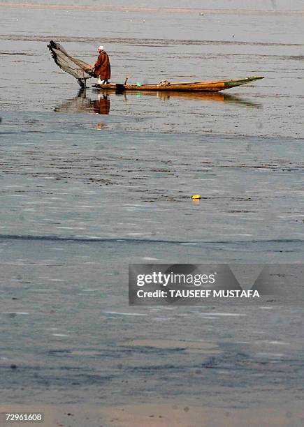 Kashmiri Muslim fisherman throws a net near a frozen portion of the Dal Lake in Srinagar, 10 January 2007. A cold wave continued to sweep most parts...