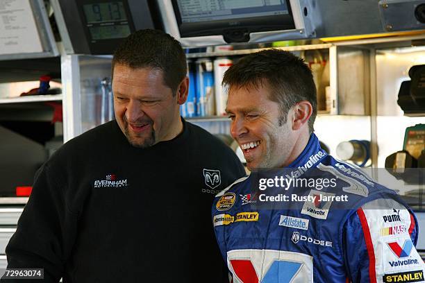 Scott Riggs , driver of the Valvoline Dodge, shares a laugh with a crew member in the garage during NASCAR testing at Daytona International Speedway...