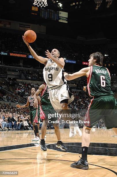 Tony Parker of the San Antonio Spurs takes the ball to the basket against Andrew Bogut of the Milwaukee Bucks during the game at the AT&T Center on...