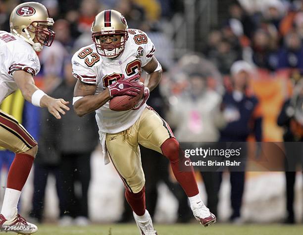 Alex Smith of the San Francisco 49ers hands off the ball to Arnaz Battle during the game against the Denver Broncos at Invesco Field at Mile High on...