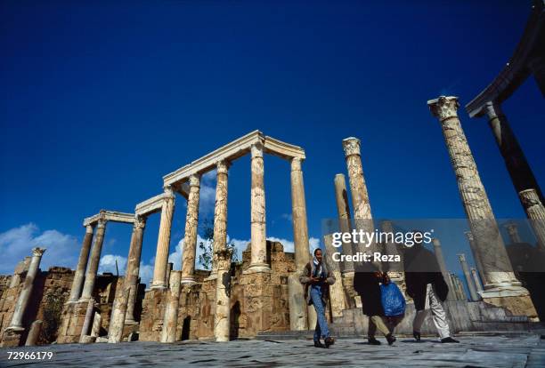 Tourists pass by the colonnades near the theater, part of the ruins of Leptis Magna, the largest city of the ancient region of Tripolitania, May 2000...