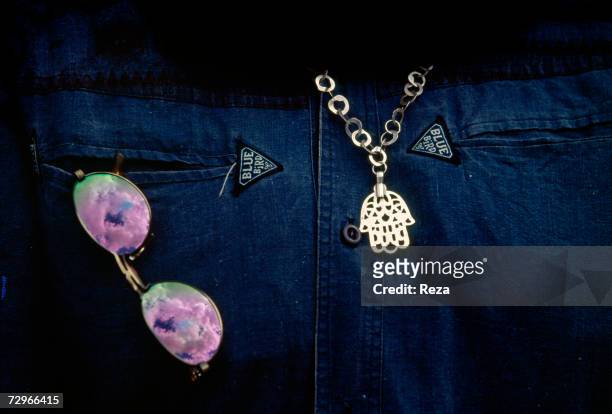 Pendant representing a Fatma hand made of silver and sunglasses are displayed on April, 2000 in Tripoli, Libya.