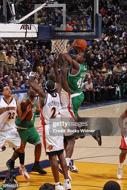 Tony Allen of the Boston Celtics takes the ball to the basket against Adonal Foyle and Mickael Pietrus of the Golden State Warriors during a game at...