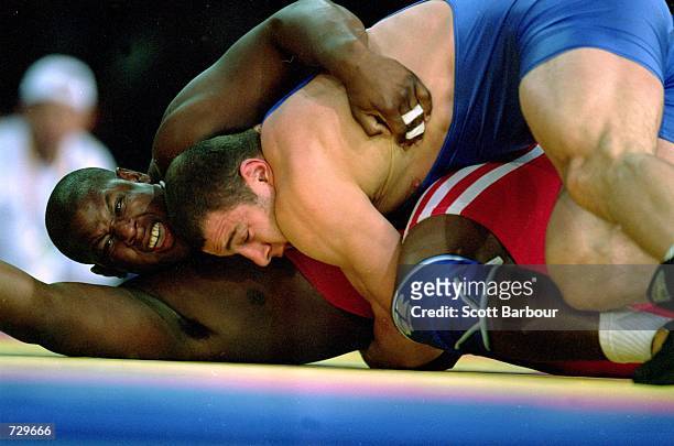 Alexis Rodriguez of Cuba gets taken down by Artur Taymazov of Uzbekistan during the Men's Freestyle Wrestling 69kg Event at the Sydney Exhibition...