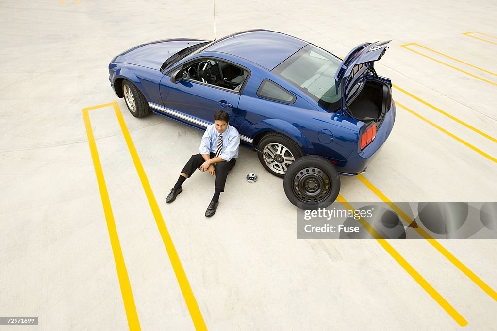 Businessman stranded with a flat tire