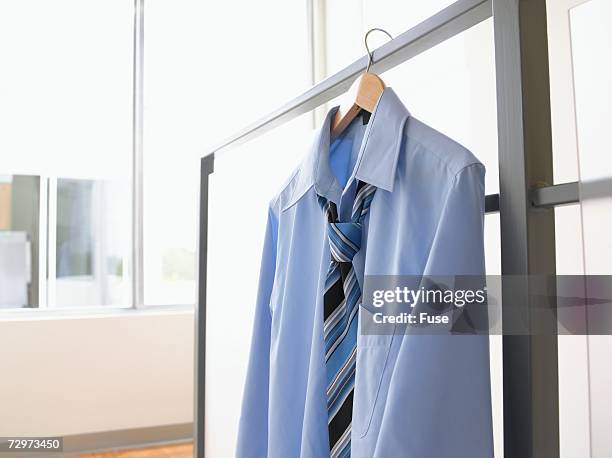 button-down shirt and necktie hanging from hanger - white button down shirt stock pictures, royalty-free photos & images