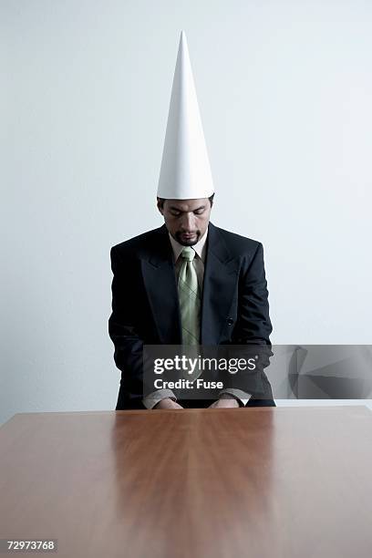 businessman in a dunce cap - dumstrut bildbanksfoton och bilder