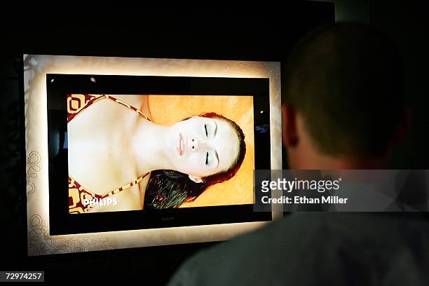 An attendee looks at an Ambilight flat television adorned with 2,200 diamonds at the Philips Electronics booth at the Las Vegas Convention Center...
