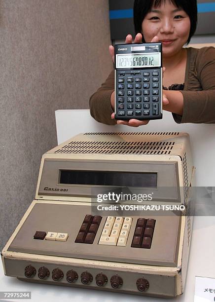 Employee for Japan's Casio Computer, Hikari Jufuku, displays a selection of the company's electronic calculators from over the years, including the...