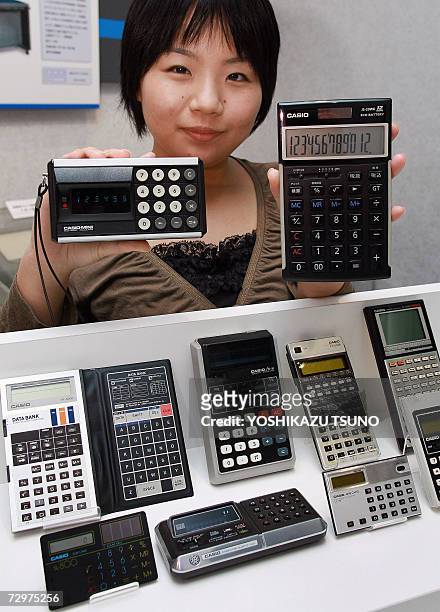 Employee for Japan's Casio Computer, Hikari Jufuku, displays a selection of the company's electronic calculators from over the years, including the...