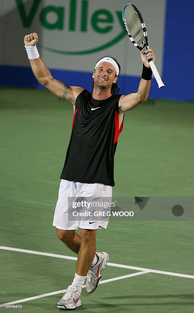 An exhausted Carlos Moya of Spain raises