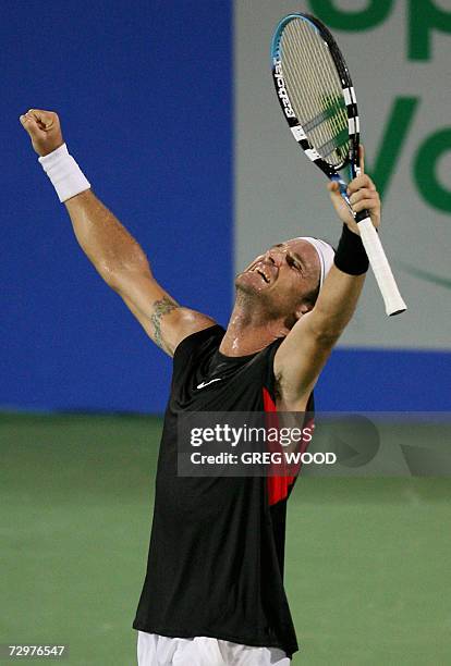 An exhausted Carlos Moya of Spain raises his arms after defeating Marcos Baghdatis of Cyprus in their quarter-final match at the Sydney International...