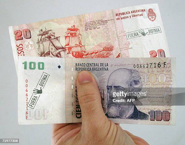 Gualeguaychu, ARGENTINA: Una persona de la ciudad de Gualeguaychu muestra billetes de moneda argentina el 10 de enero de 2007, a los cuales les...