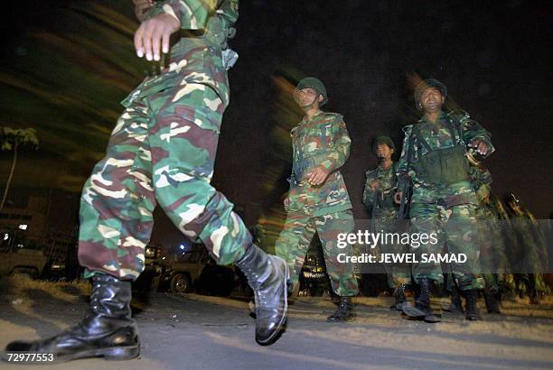 Bangladeshi military soldiers walk towards their makeshift camp near the presidential palace following their deployment after Bangladeshi President...