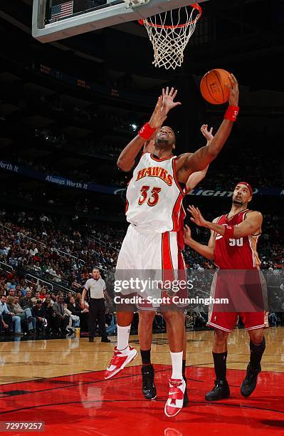 Shelden Williams of the Atlanta Hawks shoots from under the basket against the Cleveland Cavaliers during the game at Philips Arena on December 27,...