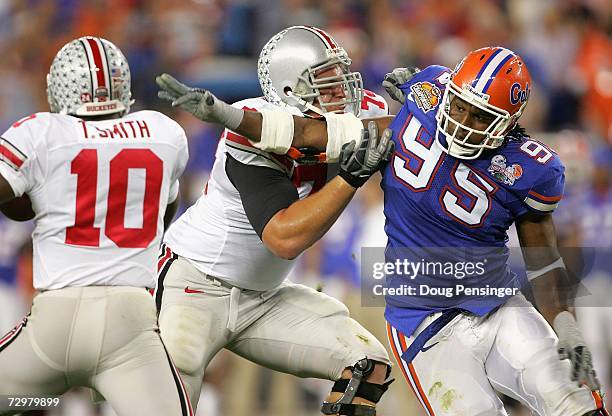 Quarterback Troy Smith of the Ohio State Buckeyes scrambles under pressure from Ray McDonald of the Florida Gators during the 2007 Tostitos BCS...