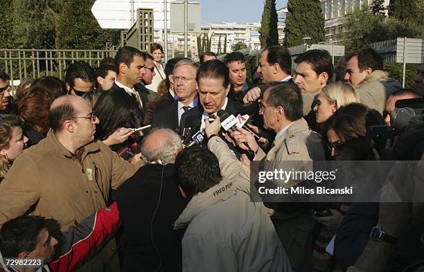 Greek Minister of Public Order, Vironas Polidoras, makes a statement as Charles Ries, the US Ambassador to Greece, listens, after unknown assailants...
