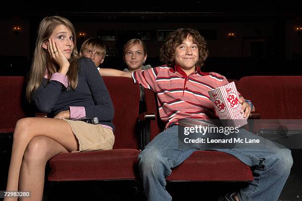 teenage couple sitting in movie theatre auditorium - divergent film stock pictures, royalty-free photos & images