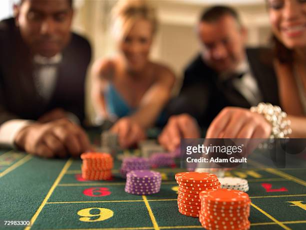 two couples gambling in casino, focus on gambling chips - roulette stock-fotos und bilder