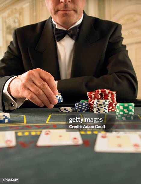 man holding gambling chips in casino, mid section - bow tie stock pictures, royalty-free photos & images