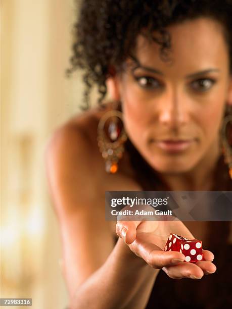 female gambler holding die - クラップス ストックフォトと画像