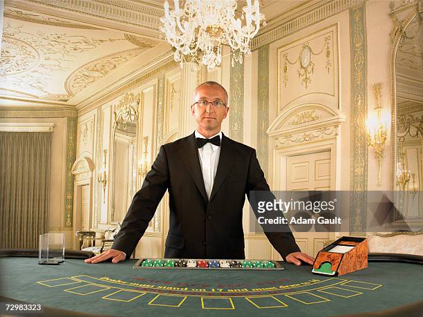 male croupier at blackjack table in casino, portrait - casino worker stock pictures, royalty-free photos & images