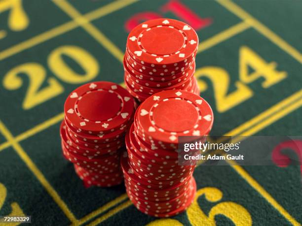 gambling chips stacked on roulette table in casino, close-up, elevated view - ficha de apuestas fotografías e imágenes de stock