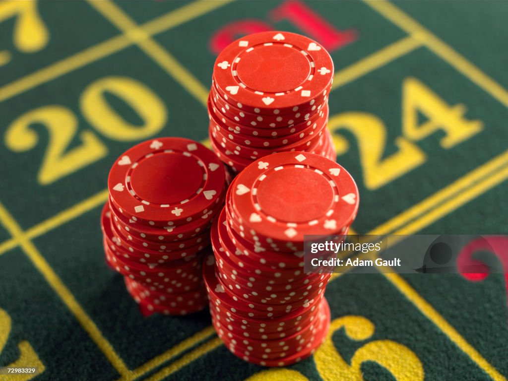 Gambling chips stacked on Roulette table in casino, close-up, elevated view