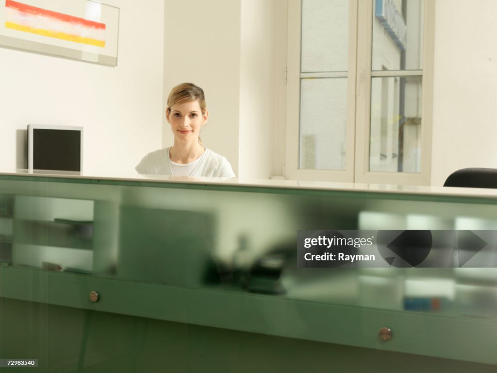 Receptionist behind desk, dentist office