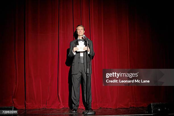 man wearing tuxedo standing on stage, showing envelope - smoking imagens e fotografias de stock