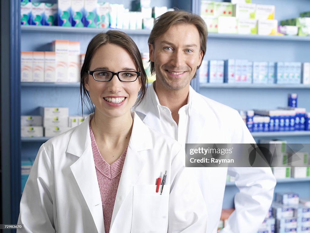 Pharmacists standing in pharmacy,portrait