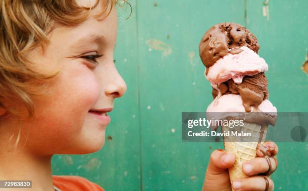 close up of boy (6-7) holding ice cream cone, side view - child eat side photos et images de collection