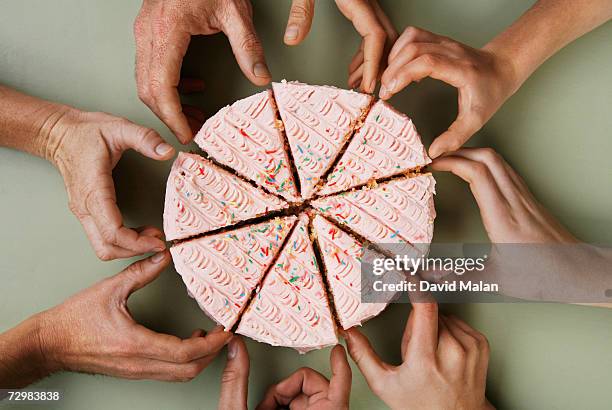 group of eight people reaching for slice of cake, close-up, overhead view - igualdad fotografías e imágenes de stock