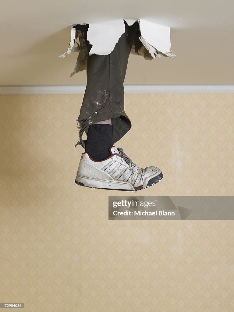 Human leg dangling from hole in ceiling