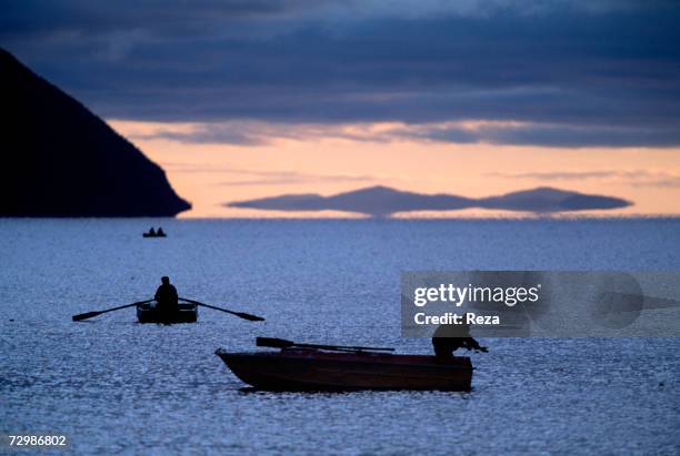 Fishermen stand on boats by the Amur River's mouth in the Okhotsk Sea October 1997 in Russian Federation.