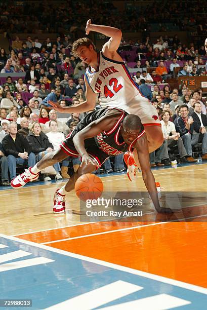 Luol Deng of the Chicago Bulls dives to keep control of the ball past David Lee of the New York Knicks at Madison Square Garden on December 22, 2006...