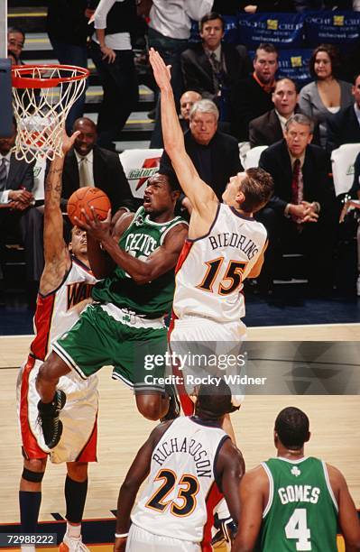 Tony Allen of the Boston Celtics takes the ball to the basket against Matt Barnes and Andris Biedrins of the Golden State Warriors during a game at...