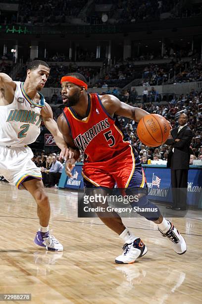 Baron Davis of the Golden State Warriors is defended by Jannero Pargo of the New Orleans/Oklahoma City Hornets during the game at the Ford Center in...