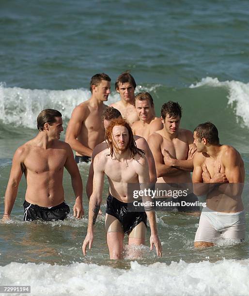 Josh Thurgood of the Hawthorn Hawks stands in the water with team-mates during a recovery session at Albert Park Beach after a Hawthorn Hawks AFL...