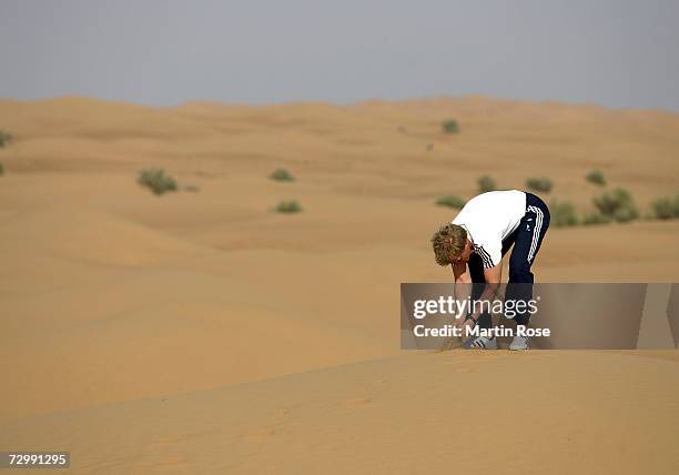 Oliver Kahn, goalkeeper of Munich, checks the desert sand during the Bayern Munich desert tour on January 13, 2007 in Dubai, United Arab Emirates.