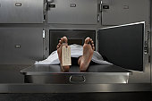 Cadaver on autopsy table, label tied to toe