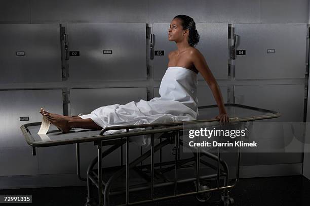 woman sitting on hospital trolley, side view - morgue woman bildbanksfoton och bilder