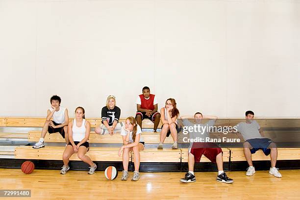 group of students (16-19) sitting on bleachers in school gym - basketball teenager stock pictures, royalty-free photos & images