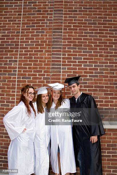 teenage male and female graduates (16-19) wearing graduation caps and gown, smiling, portrait - male student wearing glasses with friends stock-fotos und bilder