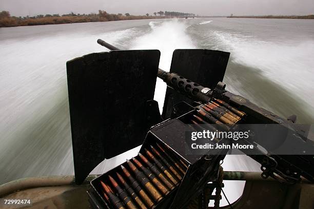 Caliber machine gun sits ready while speeding along the Euphrates River after U.S. Marines were fired on by insurgents east of Ramadi January 13,...