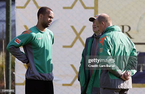 Injured Patrick Owomoyela speaks with doctor Goetz Dimanski and coach Thomas Schaaf during the Werder Bremen training camp on January 12, 2007 in...