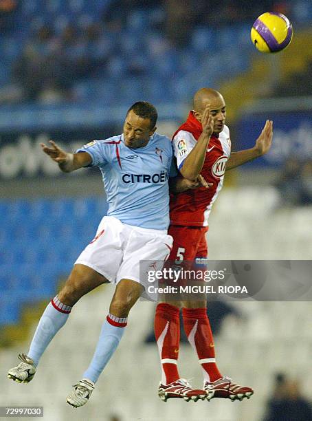 Celta Vigo's Brazilian striker Fernando Nelo Baiano and Atletico Madrid's French midfielder Peter Bernard Luccin head for the ball during their...