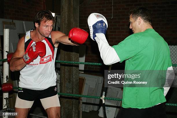 Aaron Hamill of the Saints spars with Australian super-middleweight boxer Danny Green during a Saint Kilda Saints AFL training session at Moorabbin...