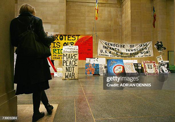 London, UNITED KINGDOM: A woman reads about the latest installation by Mark Wallinger at Tate Britain in London, 15 January 2007. Wallinger has...